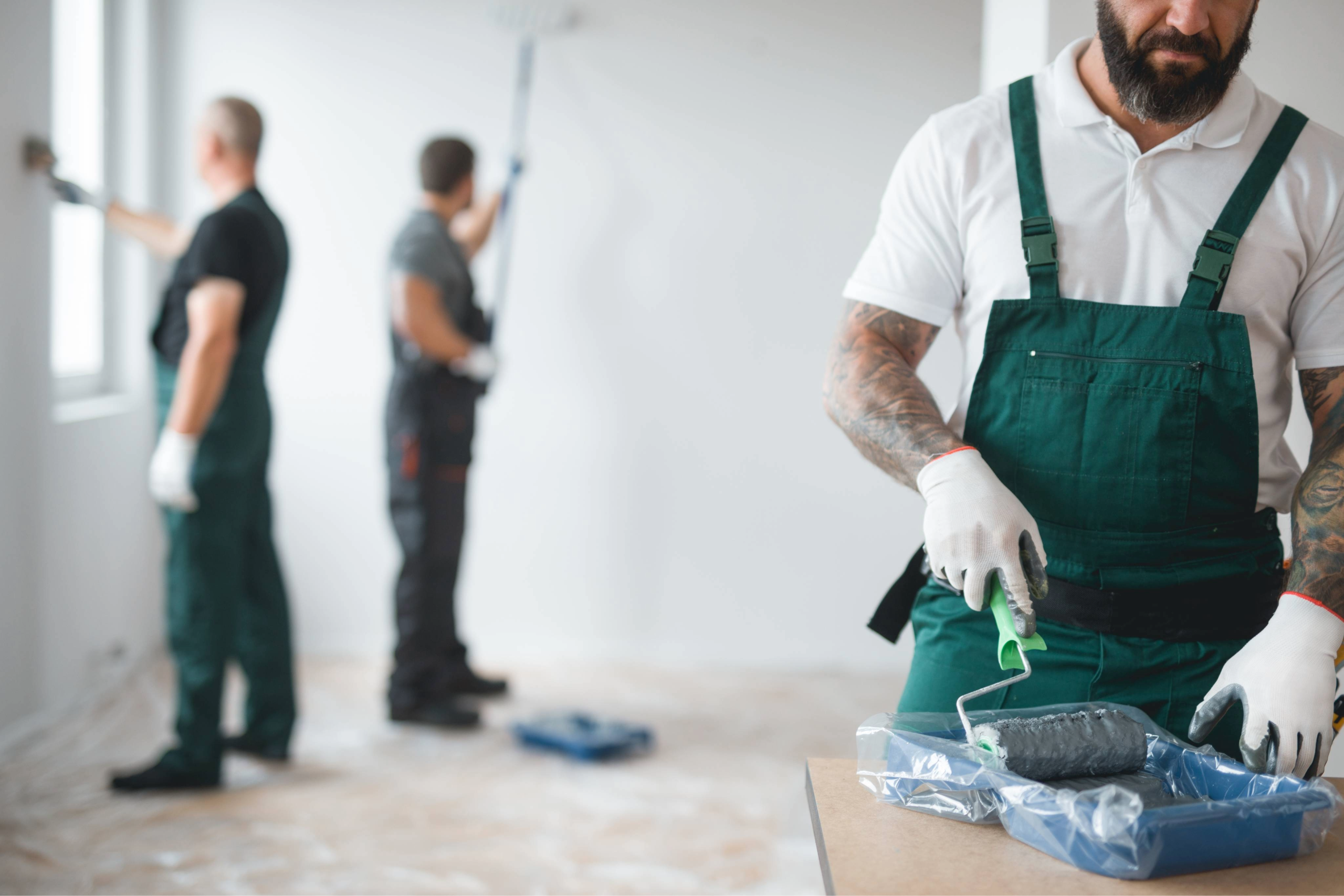 Image of men painting walls in a professional environment.